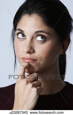 Young woman thinking with finger on chin View Large Photo Image Stock Image - Young woman thinking with finger on chin. Fotosearch
