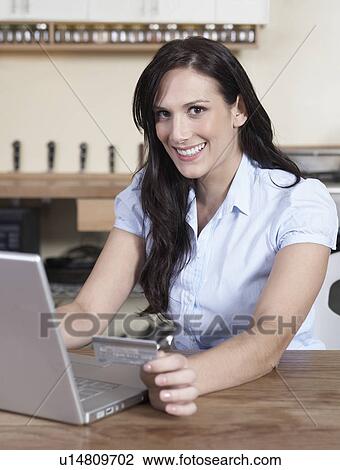 Stock Image - Mid-Adult Woman Shopping Online. Fotosearch