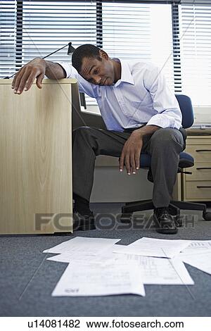 Stock Image - Bored Mid Adult Man Doing Paperwork. Fotosearch