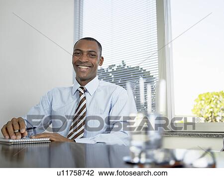 Businessman laughing by table (portrait) View Large Photo Image Stock Image - Businessman laughing by table (portrait). Fotosearch
