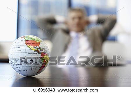 Businessman near globe (focus on foreground) View Large Photo Image Stock Image - Businessman near globe (focus on foreground). Fotosearch