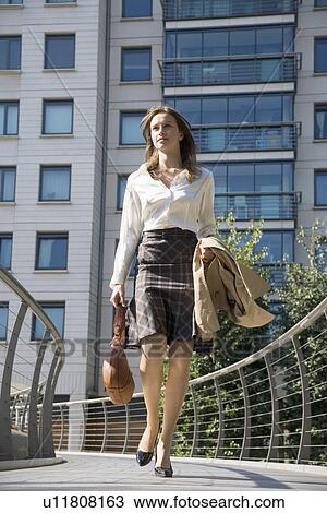 Businesswoman walking on bridge (low angle view) View Large Photo Image Stock Image - Businesswoman walking on bridge (low angle view). Fotosearch