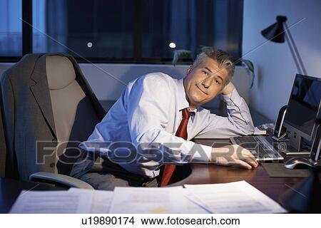 Picture - Male office worker working late. Fotosearch