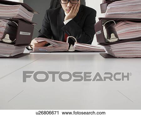 Stock Image - Office Worker Reading Documents. Fotosearch