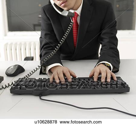 Office Worker Typing with Keyboard While on Phone View Large Photo Image Stock Photo - Office Worker Typing with Keyboard While on Phone. Fotosearch