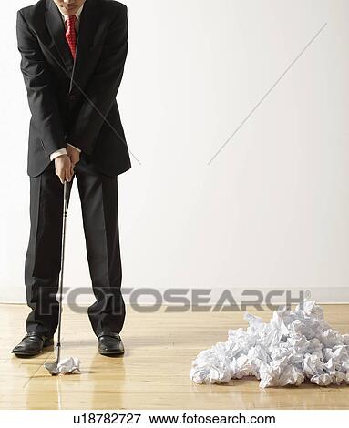 Stock Photo - Businessman Playing Golf with Crumpled Paper. Fotosearch