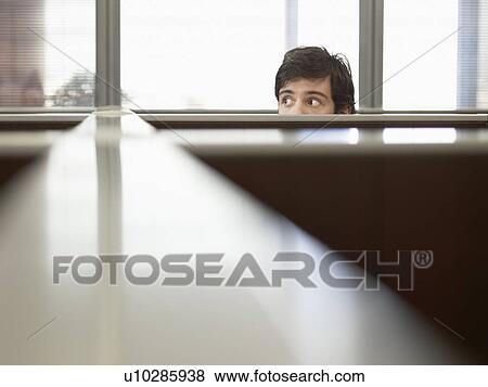 Stock Photo - Male office worker peeping over partition walls. Fotosearch