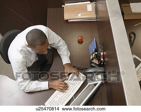 Male office worker typing at desk (directly above) View Large Photo Image Picture - Male office worker typing at desk (directly above). Fotosearch