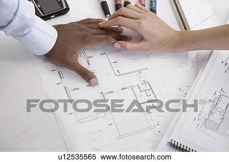 Stock Photography - Two architects with blueprints (focus on hands). Fotosearch