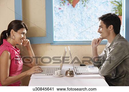 Woman and man using laptop computers in café View Large Photo Image Stock Image - Woman and man using laptop computers in café. Fotosearch