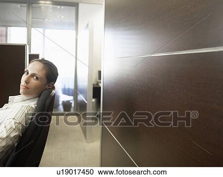 Stock Image - Woman sitting on office chair (portrait). Fotosearch