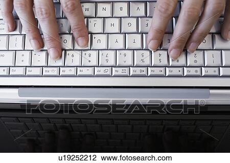 Stock Image - Woman's hands typing with laptop (close-up, directly above). Fotosearch