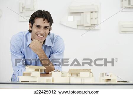 Stock Image - Young architect by model houses (portrait). Fotosearch