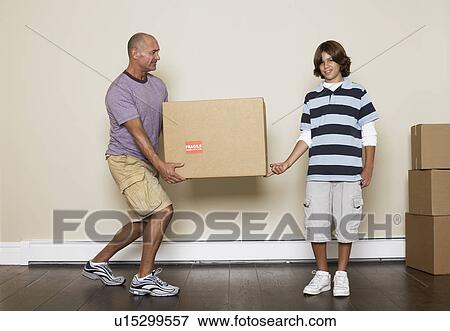 Stock Photo - Father and son carrying cardboard box. Fotosearch