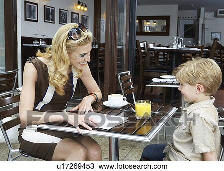 Mid adult woman talking to son in café View Large Photo Image Stock Image - Mid adult woman talking to son in café. Fotosearch