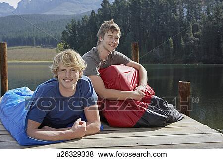 Stock Photo - Two Teenage Boys in Sleeping Bags by Lake. Fotosearch