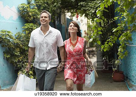Stock Image - Couple carrying shopping bags. Fotosearch