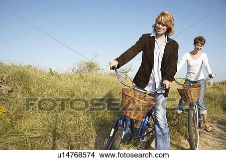Picture - Couple cycling in field. Fotosearch