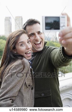 Stock Image - Couple photographing themselves. Fotosearch