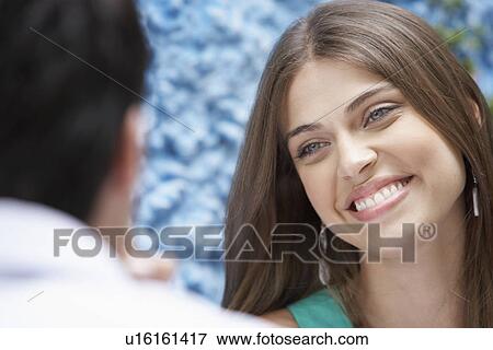 Stock Photo - Woman smiling to man. Fotosearch