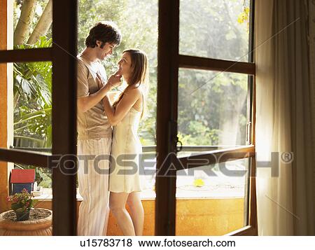 Stock Photo - Young couple hugging on doorway. Fotosearch