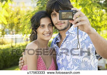 Stock Image - Young couple photographing themselves. Fotosearch