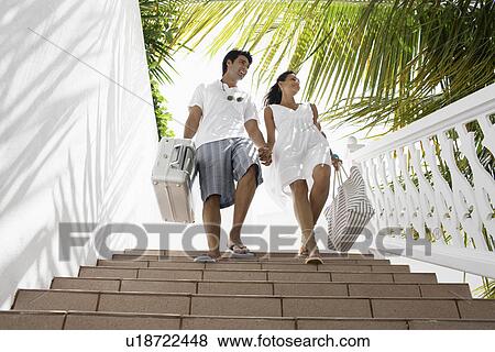 Young couple walking down steps with luggage View Large Photo Image Stock Photo - Young couple walking down steps with luggage. Fotosearch