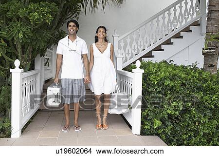 Young couple with luggage standing at resort View Large Photo Image Picture - Young couple with luggage standing at resort. Fotosearch