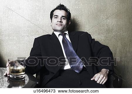 Portrait of a businessman holding a glass of whiskey View Large Photo Image Stock Image - Portrait of a businessman holding a glass of whiskey. Fotosearch