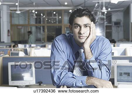 Stock Photograph - Portrait of a businessman standing in an office. Fotosearch