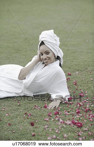 Portrait of a teenage girl in a bathrobe lying on the grass View Large Photo Image Stock Photo - Portrait of a teenage girl in a bathrobe lying on the grass. Fotosearch
