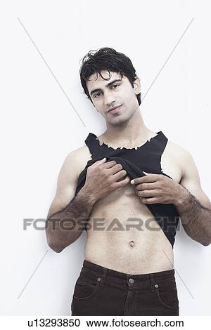 Stock Image - Portrait of a young man showing his abdomen. Fotosearch