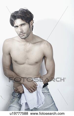 Portrait of a young man standing bare chested View Large Photo Image Stock Photo - Portrait of a young man standing bare chested. Fotosearch