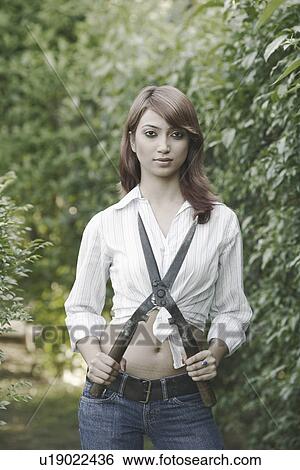 Stock Photograph - Portrait of a young woman holding a hedge clipper. Fotosearch