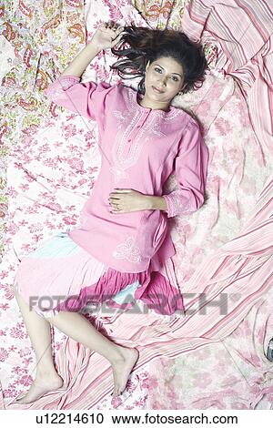 Portrait of a young woman lying on her back View Large Photo Image Stock Image - Portrait of a young woman lying on her back. Fotosearch