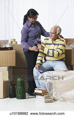 Stock Image - Mature couple raising a toast. Fotosearch