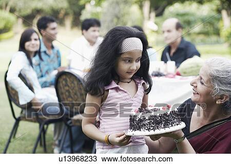 Mature woman and a girl holding a cake View Large Photo Image Stock Image - Mature woman and a girl holding a cake. Fotosearch