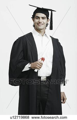Portrait of a male graduate holding a diploma View Large Photo Image Stock Photo - Portrait of a male graduate holding a diploma. Fotosearch