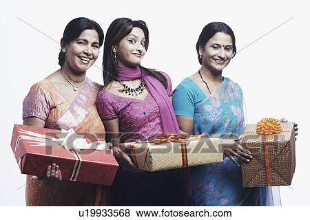 Stock Photo - Portrait of a mother and her two daughters holding gifts. Fotosearch