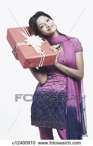 Portrait of a young woman holding a gift View Large Photo Image Stock Image - Portrait of a young woman holding a gift. Fotosearch