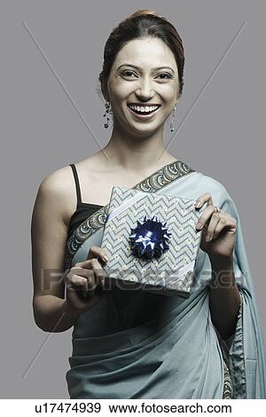 Portrait of a young woman holding a gift View Large Photo Image Stock Photo - Portrait of a young woman holding a gift. Fotosearch