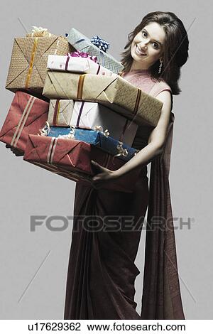 Portrait of a young woman holding gifts View Large Photo Image Stock Image - Portrait of a young woman holding gifts. Fotosearch