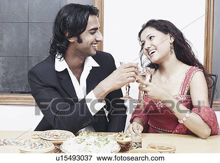 Young couple toasting with wineglass at the dining table View Large Photo Image Stock Photo - Young couple toasting with wineglass at the dining table. Fotosearch