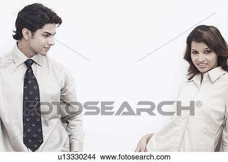 Picture - Close-up of a businessman looking at a businesswoman smiling. Fotosearch