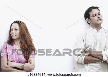 Picture - Close-up of a mid adult couple standing with their arms crossed. Fotosearch