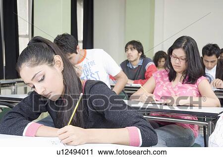 Stock Image - Group of young people in a classroom. Fotosearch