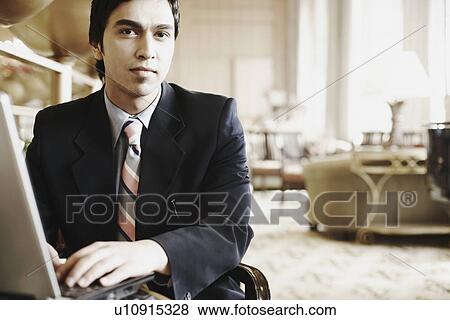 Stock Photo - Portrait of a businessman using a laptop. Fotosearch