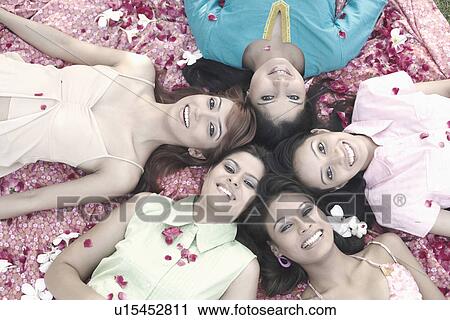 Stock Image - Portrait of a teenage girl and four young women lying on their back. Fotosearch