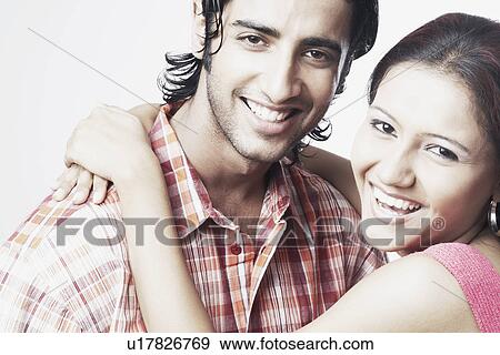 Portrait of a young woman embracing a young man View Large Photo Image Stock Photo - Portrait of a young woman embracing a young man. Fotosearch