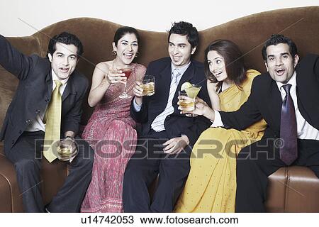 Three young men and two young women holding glasses View Large Photo Image Stock Image - Three young men and two young women holding glasses. Fotosearch